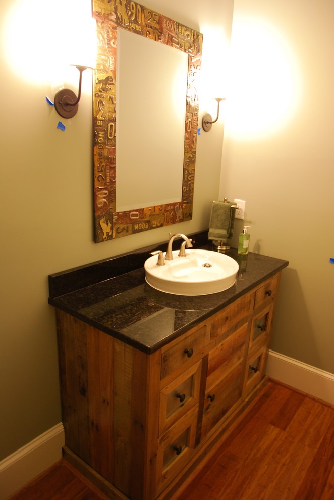 アトランタにある小さなラスティックスタイルのおしゃれなバスルーム (浴槽なし) (オーバーカウンターシンク、家具調キャビネット、ヴィンテージ仕上げキャビネット、御影石の洗面台、ベージュの壁、無垢フローリング) の写真