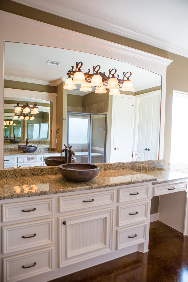 Example of a mid-sized master beige tile and terra-cotta tile concrete floor bathroom design in Houston with a vessel sink, recessed-panel cabinets, white cabinets, granite countertops and beige walls