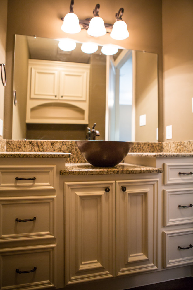 Rustik inredning av ett mellanstort badrum med dusch, med ett fristående handfat, luckor med profilerade fronter, vita skåp, granitbänkskiva, beige väggar och betonggolv