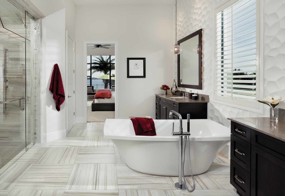 Inspiration for a medium sized classic ensuite bathroom in Orlando with shaker cabinets, dark wood cabinets, a freestanding bath, an alcove shower, a one-piece toilet, beige tiles, grey tiles, white tiles, stone slabs, white walls, porcelain flooring, a submerged sink and zinc worktops.