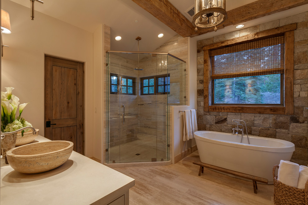 Идея дизайна: главная ванная комната в стиле рустика с отдельно стоящей ванной, угловым душем, бежевой плиткой, бежевыми стенами, настольной раковиной, бежевым полом, душем с распашными дверями и серой столешницей