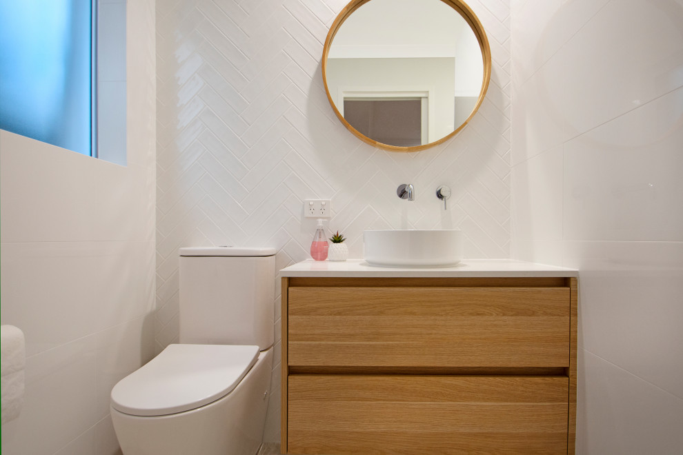 Cette image montre une grande salle d'eau design en bois clair avec un placard à porte plane, un carrelage gris, mosaïque, un plan de toilette en quartz modifié, un plan de toilette blanc, meuble double vasque et meuble-lavabo suspendu.