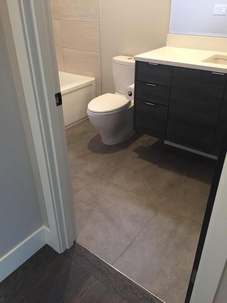 Inspiration for a small modern 3/4 gray tile and porcelain tile ceramic tile and gray floor bathroom remodel in Seattle with flat-panel cabinets, dark wood cabinets, a one-piece toilet, gray walls, an undermount sink and solid surface countertops