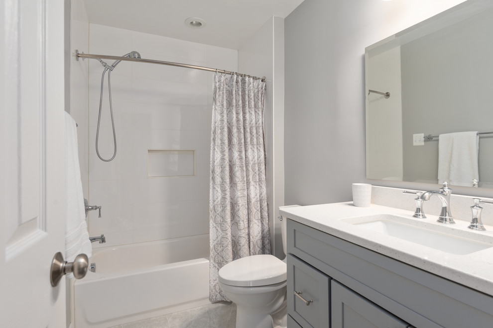 Exempel på ett litet klassiskt vit vitt badrum, med skåp i shakerstil, grå skåp, ett badkar i en alkov, en dusch/badkar-kombination, en toalettstol med separat cisternkåpa, vit kakel, grå väggar, ett undermonterad handfat, bänkskiva i kvarts, grått golv och dusch med duschdraperi
