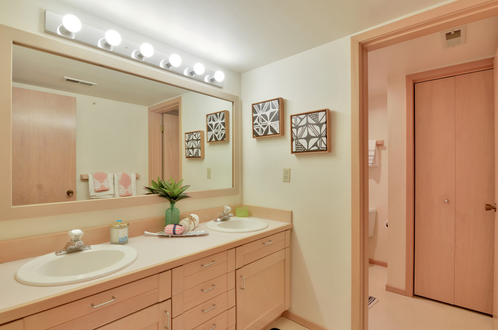 Пример оригинального дизайна: большая ванная комната в современном стиле с фасадами с выступающей филенкой, светлыми деревянными фасадами, унитазом-моноблоком, бежевыми стенами, полом из керамической плитки, душевой кабиной, монолитной раковиной, столешницей из ламината, бежевым полом и белой столешницей