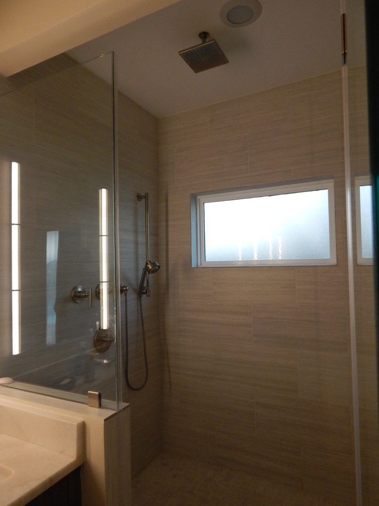 Mid-sized transitional beige tile and porcelain tile brown floor alcove shower photo in Houston with dark wood cabinets, beige walls, an undermount sink, marble countertops and a hinged shower door