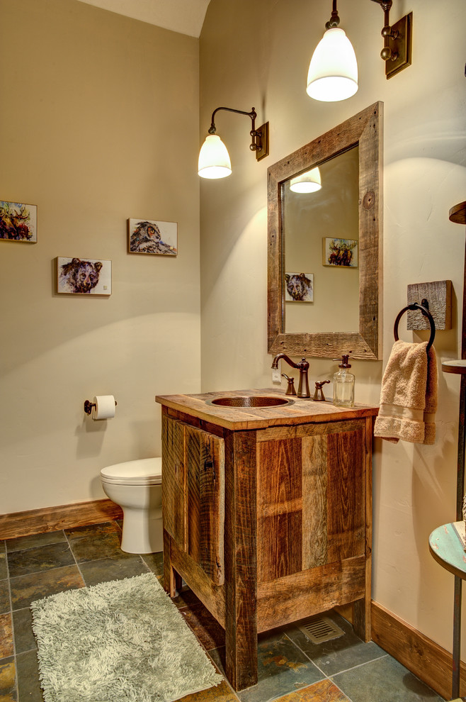 Пример оригинального дизайна: ванная комната среднего размера в стиле рустика с искусственно-состаренными фасадами, унитазом-моноблоком, бежевыми стенами, полом из сланца, душевой кабиной, накладной раковиной и столешницей из дерева