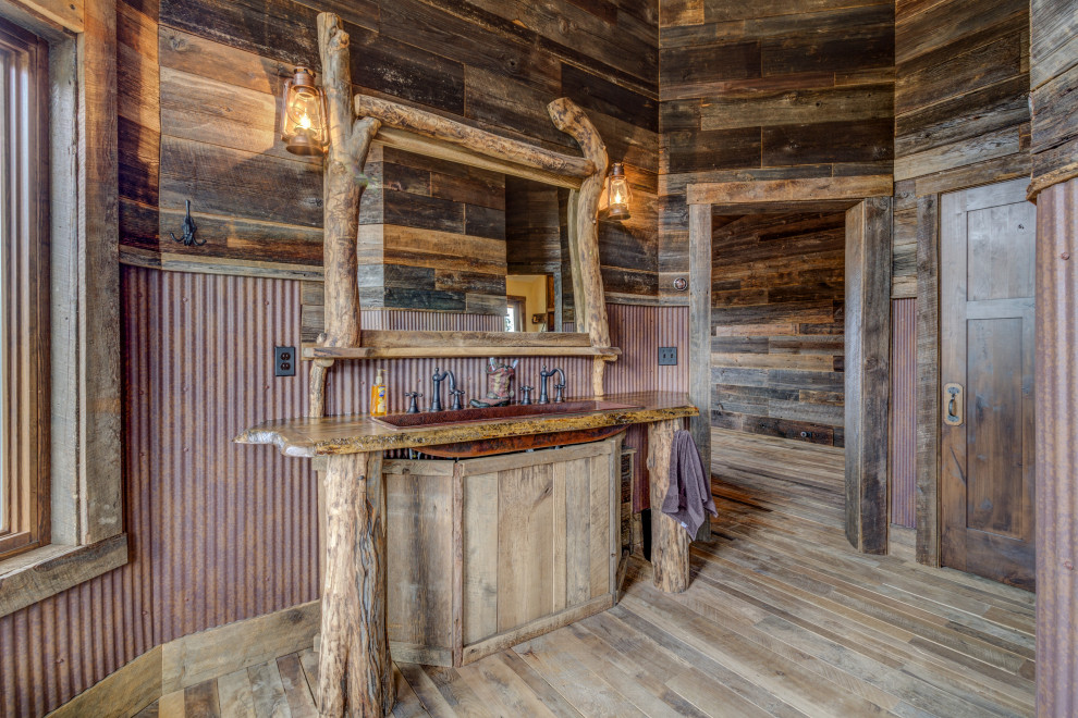 Ejemplo de cuarto de baño doble rural con paredes marrones, suelo de madera en tonos medios, lavabo de seno grande, suelo marrón, encimeras marrones, boiserie y madera