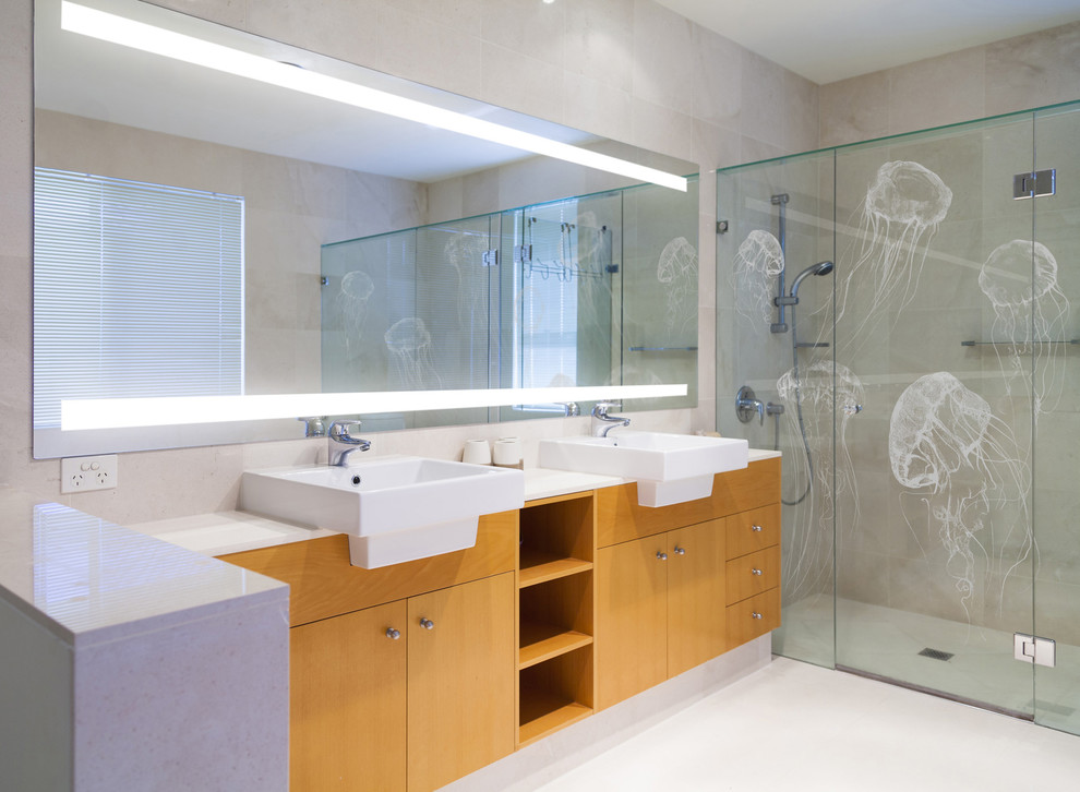 На фото: ванная комната в современном стиле с накладной раковиной, плоскими фасадами, фасадами цвета дерева среднего тона, душем в нише, бежевой плиткой и бежевыми стенами с