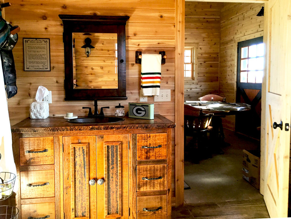 Urige Sauna mit Schrankfronten mit vertiefter Füllung, hellen Holzschränken, Waschtisch aus Holz, braunem Holzboden und Einbauwaschbecken in Sonstige