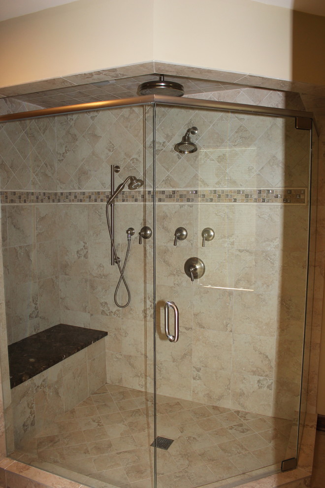 Foto de cuarto de baño principal, doble y a medida, clásico, grande, con armarios con paneles con relieve, puertas de armario beige, bañera exenta, ducha esquinera, sanitario de dos piezas, baldosas y/o azulejos beige, baldosas y/o azulejos de porcelana, paredes beige, suelo de baldosas de porcelana, lavabo bajoencimera, encimera de mármol, suelo beige, ducha con puerta con bisagras, encimeras marrones y banco de ducha