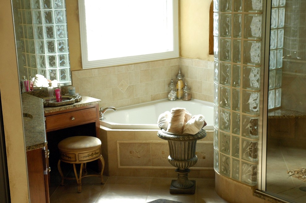 Imagen de cuarto de baño principal clásico con lavabo bajoencimera, puertas de armario de madera oscura, encimera de granito, bañera esquinera, ducha esquinera, baldosas y/o azulejos beige y paredes amarillas