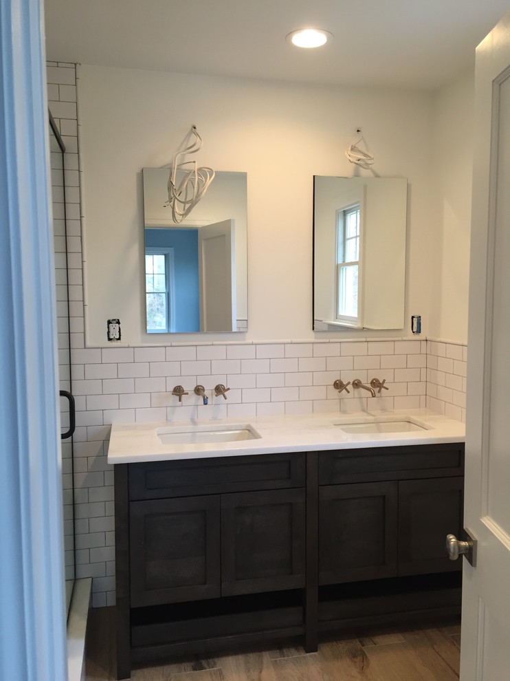 Example of a small classic master white tile and subway tile corner shower design in New York with white walls, a hinged shower door, shaker cabinets, dark wood cabinets and an undermount sink
