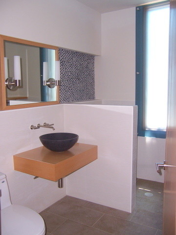 Foto på ett litet funkis badrum för barn, med ett fristående handfat, släta luckor, skåp i ljust trä, träbänkskiva, en kantlös dusch, blå kakel, porslinskakel, vita väggar och klinkergolv i porslin