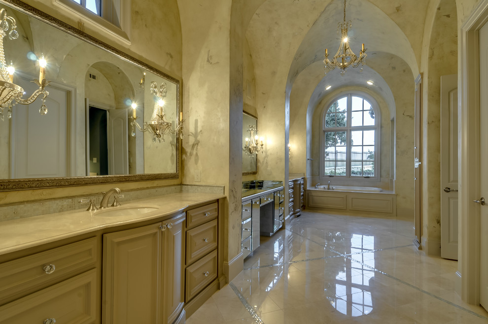 Bild på ett medelhavsstil en-suite badrum, med ett undermonterad handfat, skåp i ljust trä, marmorbänkskiva, ett platsbyggt badkar, beige kakel och beige väggar