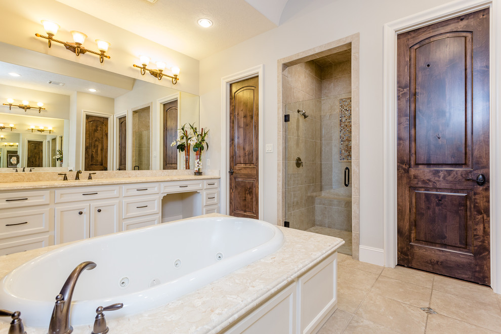 Large mediterranean ensuite bathroom in Houston with recessed-panel cabinets, white cabinets, a built-in bath, a built-in shower, a two-piece toilet, beige tiles, travertine tiles, beige walls, travertine flooring, a submerged sink, granite worktops, beige floors, an open shower and beige worktops.