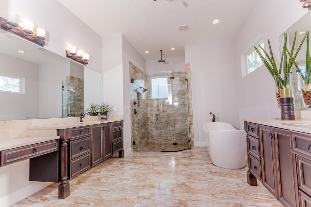 Diseño de cuarto de baño principal contemporáneo grande con armarios tipo mueble, puertas de armario con efecto envejecido, bañera exenta, ducha esquinera, paredes grises y lavabo bajoencimera