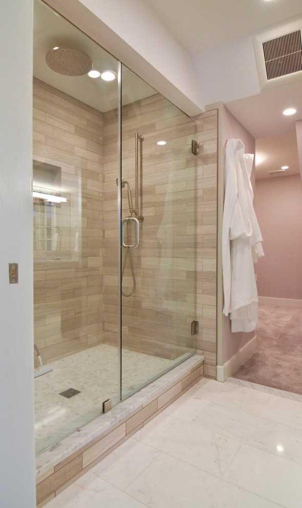 Large industrial ensuite bathroom in Philadelphia with recessed-panel cabinets, grey cabinets, a freestanding bath, an alcove shower, a two-piece toilet, beige tiles, stone tiles, beige walls, porcelain flooring, a submerged sink, marble worktops, white floors, a hinged door and multi-coloured worktops.