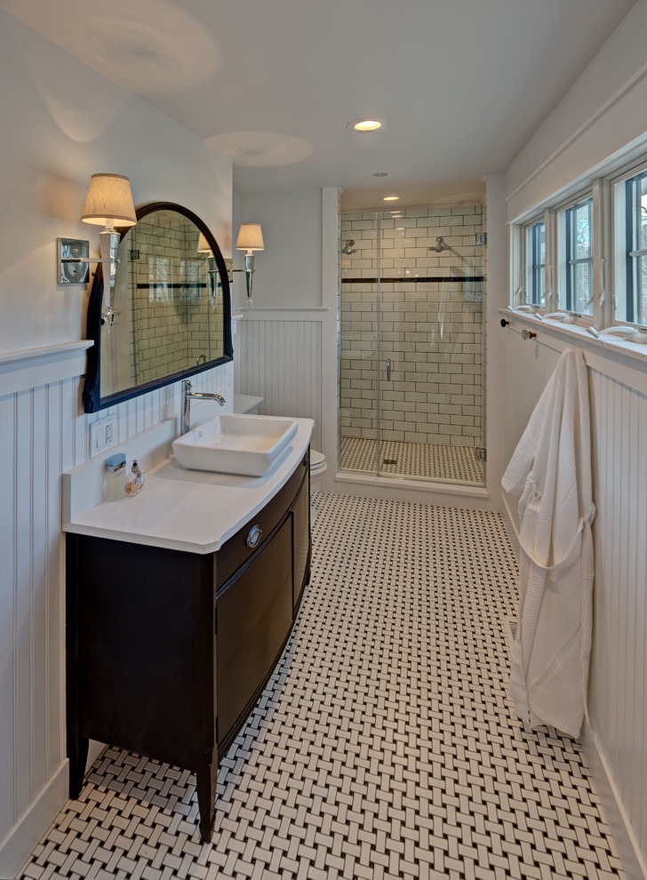 Idéer för mellanstora amerikanska badrum med dusch, med möbel-liknande, skåp i mörkt trä, en dusch i en alkov, vit kakel, porslinskakel, vita väggar, mosaikgolv, ett fristående handfat, bänkskiva i kvartsit, dusch med gångjärnsdörr, en toalettstol med separat cisternkåpa och flerfärgat golv
