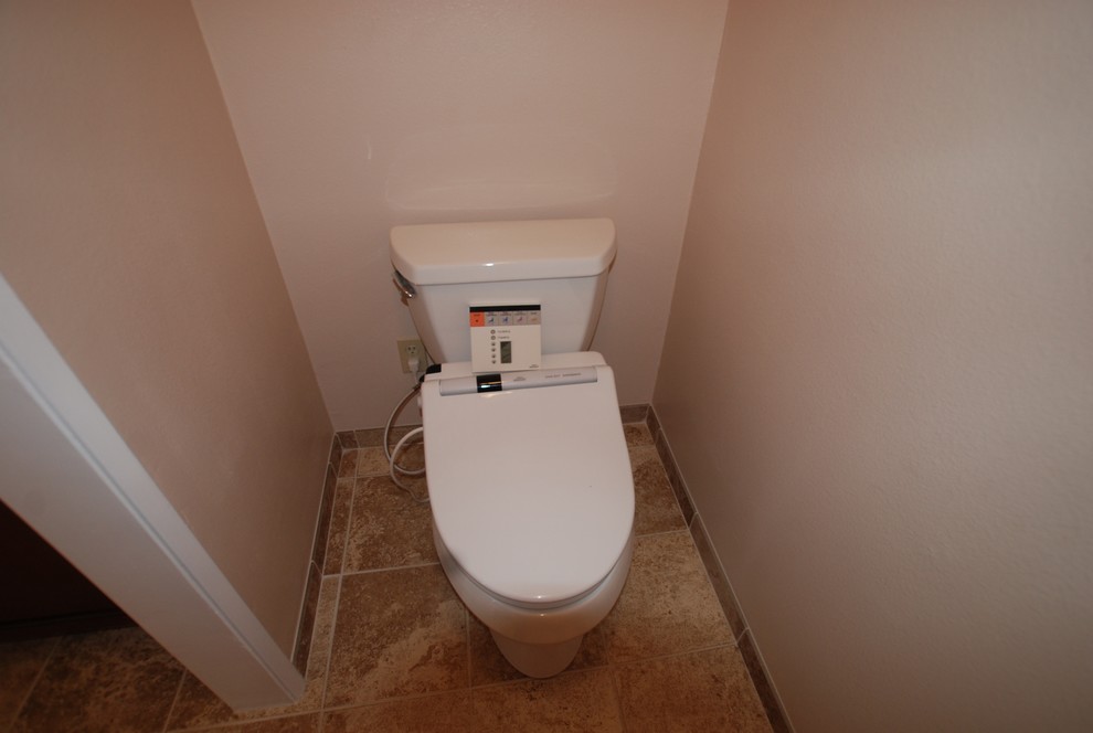 Idéer för att renovera ett mellanstort medelhavsstil en-suite badrum, med ett undermonterad handfat, luckor med infälld panel, skåp i mörkt trä, granitbänkskiva, en dusch i en alkov, en toalettstol med separat cisternkåpa, beige kakel, stenkakel, vita väggar och klinkergolv i porslin