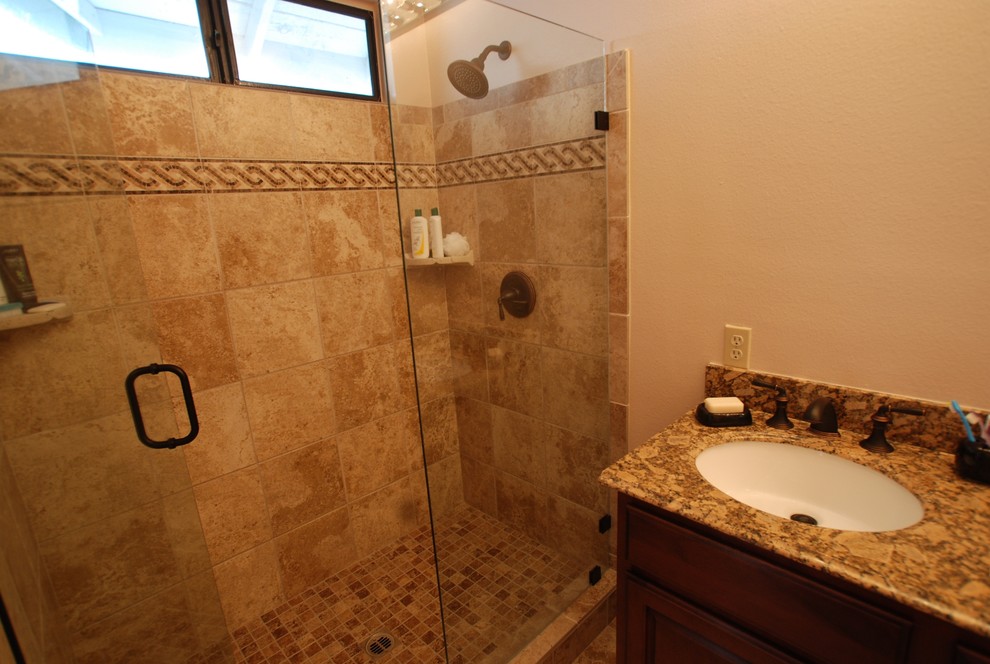 Mid-sized tuscan master beige tile and stone tile porcelain tile alcove shower photo in Orange County with an undermount sink, recessed-panel cabinets, dark wood cabinets, granite countertops, a two-piece toilet and white walls