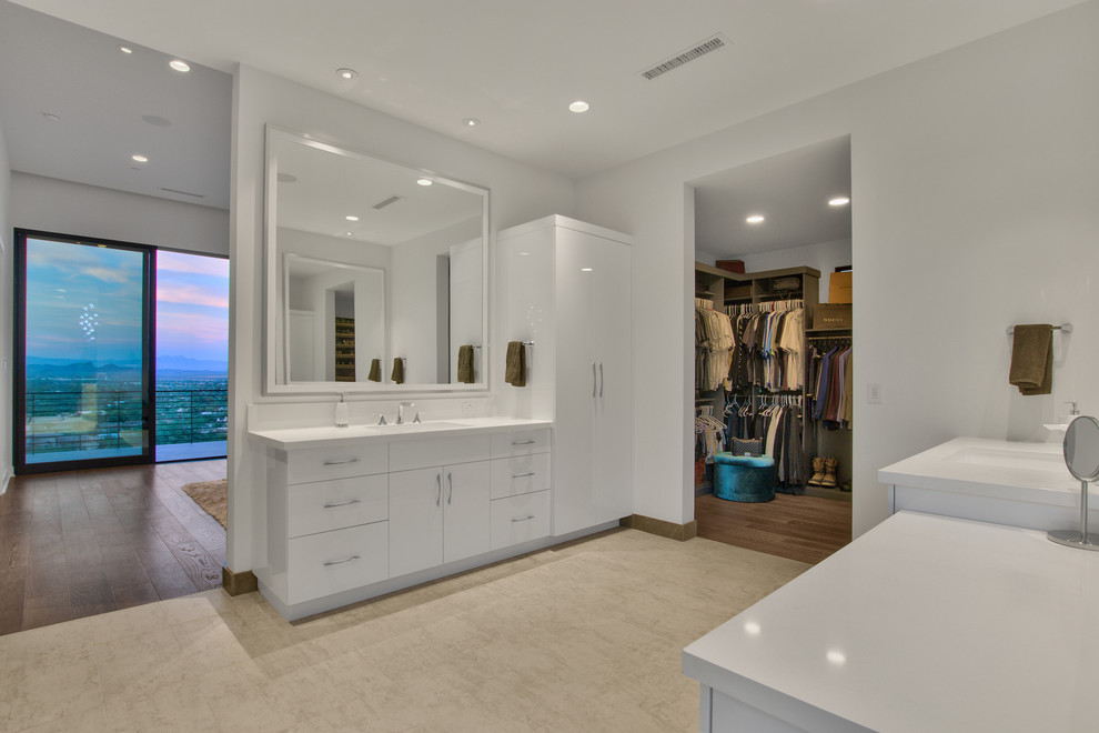 Inspiration för stora moderna vitt en-suite badrum, med släta luckor, vita skåp, ett fristående badkar, vita väggar, mellanmörkt trägolv, ett undermonterad handfat, bänkskiva i akrylsten och brunt golv