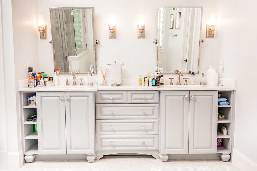 Ejemplo de cuarto de baño principal clásico grande con armarios con paneles con relieve, puertas de armario grises, baldosas y/o azulejos grises, paredes grises y lavabo bajoencimera