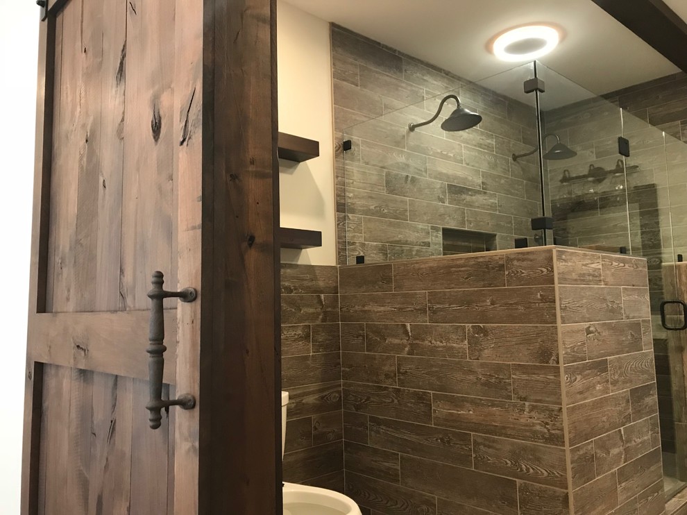 Rustik inredning av ett mellanstort en-suite badrum, med beige väggar, kalkstensgolv, beiget golv, en hörndusch, en toalettstol med hel cisternkåpa, brun kakel, porslinskakel och dusch med gångjärnsdörr