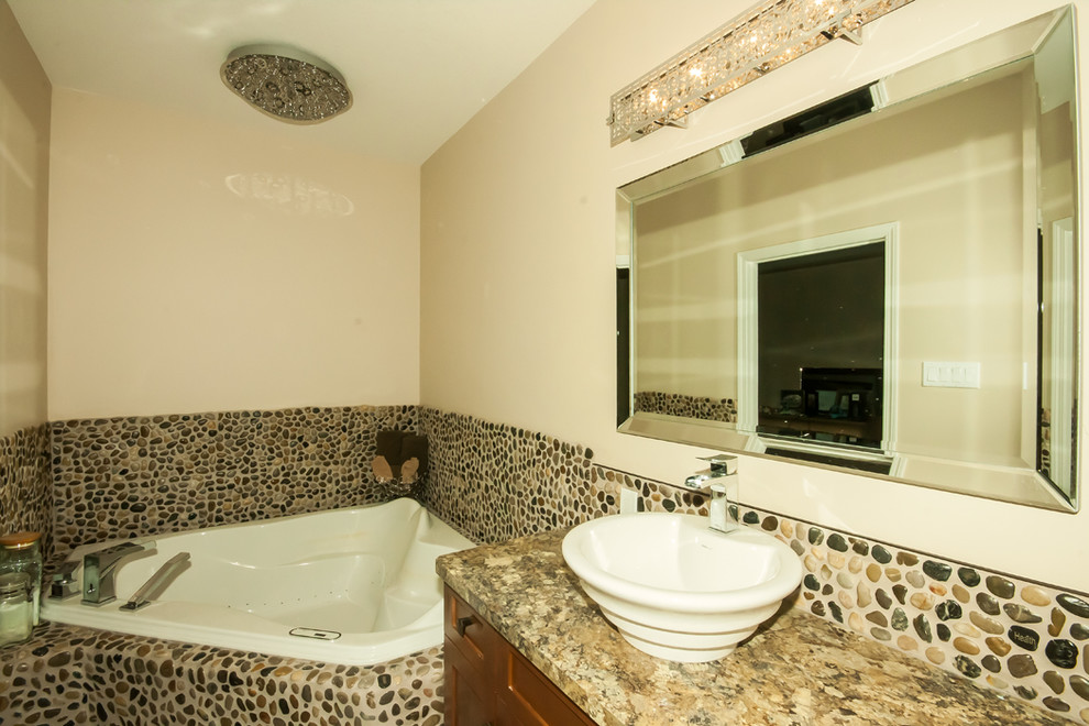 Idée de décoration pour une grande salle de bain principale craftsman en bois brun avec une vasque, un placard à porte shaker, un plan de toilette en stratifié, une baignoire d'angle, une douche double, WC séparés, un carrelage marron, une plaque de galets, un mur beige et un sol en galet.