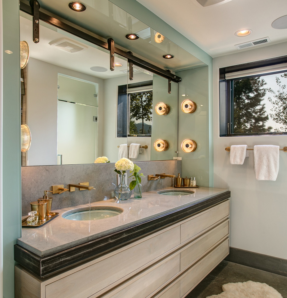 На фото: главная ванная комната среднего размера в современном стиле с врезной раковиной, светлыми деревянными фасадами, столешницей из искусственного кварца, белыми стенами, бетонным полом, плоскими фасадами и окном