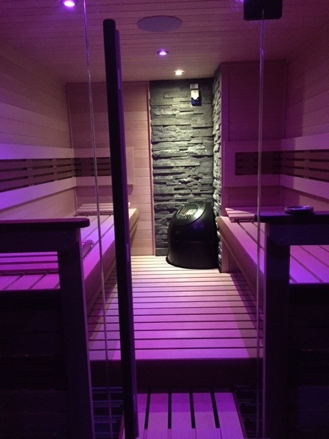 Пример оригинального дизайна: большая баня и сауна в скандинавском стиле с душевой комнатой, светлым паркетным полом, бежевым полом, коричневыми стенами и душем с распашными дверями