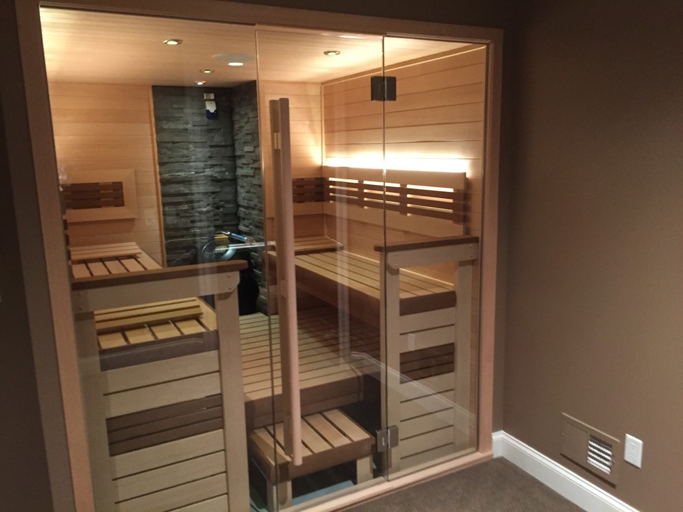 Réalisation d'un grand sauna nordique avec un espace douche bain, parquet clair, un sol beige, un mur marron et une cabine de douche à porte battante.