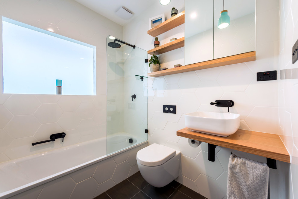 На фото: ванная комната в современном стиле с душем над ванной, инсталляцией, белой плиткой, душевой кабиной, настольной раковиной, столешницей из дерева, черным полом, открытым душем, коричневой столешницей и керамической плиткой