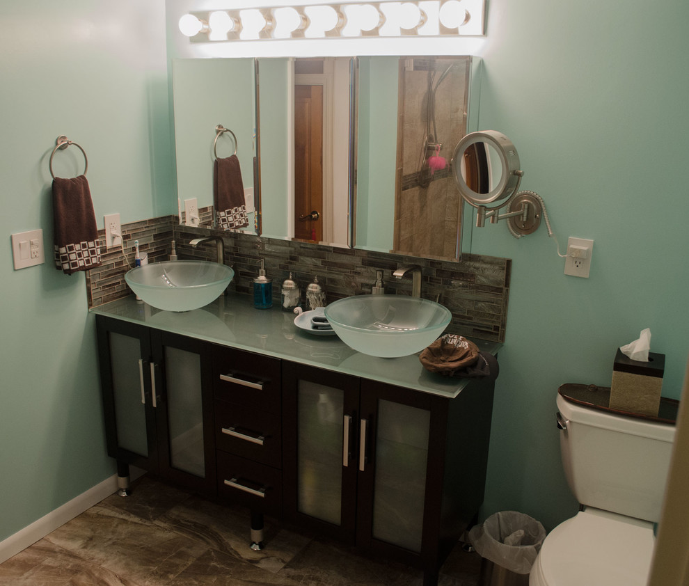 Пример оригинального дизайна: главная ванная комната среднего размера в стиле неоклассика (современная классика) с стеклянными фасадами, темными деревянными фасадами, раздельным унитазом, стеклянной плиткой, зелеными стенами, настольной раковиной и стеклянной столешницей