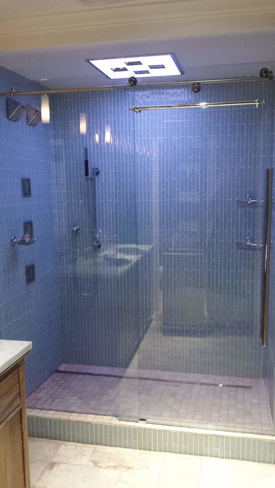 Imagen de cuarto de baño principal contemporáneo de tamaño medio con armarios con paneles empotrados, puertas de armario de madera oscura, ducha empotrada, baldosas y/o azulejos azules, azulejos en listel, paredes azules, suelo de baldosas de cerámica, lavabo bajoencimera y encimera de mármol