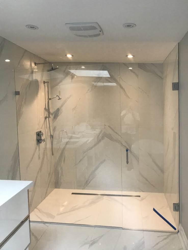 Photo of a medium sized modern shower room bathroom in Toronto with flat-panel cabinets, white cabinets, an alcove shower, white walls, marble flooring, solid surface worktops, white floors, a hinged door and white worktops.