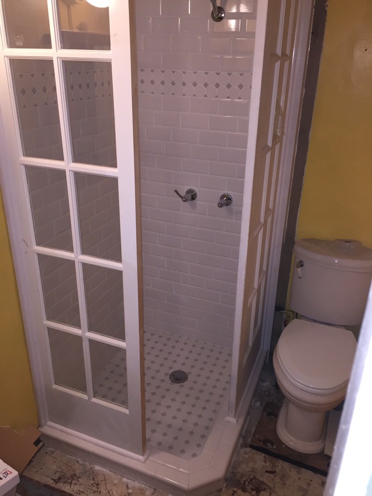 Inredning av ett litet badrum med dusch, med vit kakel och tunnelbanekakel