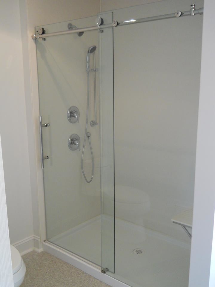 Ejemplo de cuarto de baño contemporáneo de tamaño medio con ducha empotrada, sanitario de una pieza, paredes blancas, suelo laminado y aseo y ducha