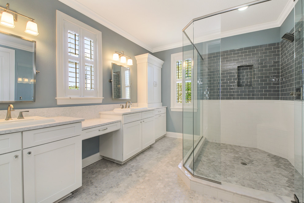 Photo of a large coastal ensuite bathroom in Tampa with shaker cabinets, white cabinets, a corner shower, grey tiles, glass tiles, blue walls, marble flooring, a built-in sink and engineered stone worktops.