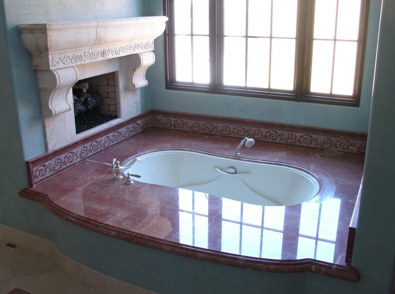 Réalisation d'une salle de bain principale tradition avec une baignoire encastrée, un mur bleu, un sol en calcaire et un plan de toilette en marbre.