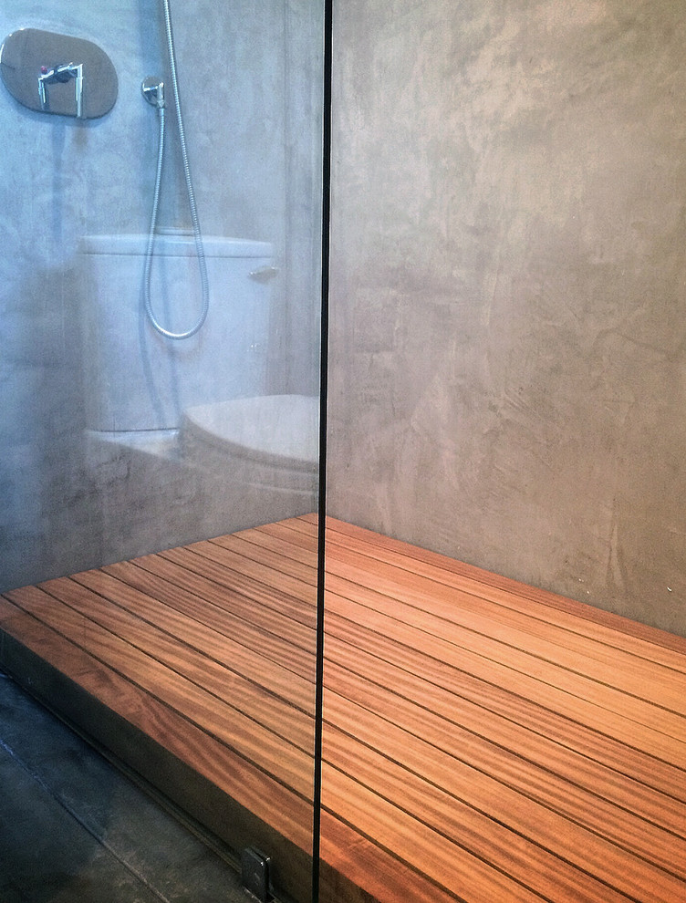 Foto di una stanza da bagno con doccia industriale di medie dimensioni con doccia a filo pavimento, pareti grigie, pavimento in legno massello medio e piastrelle grigie