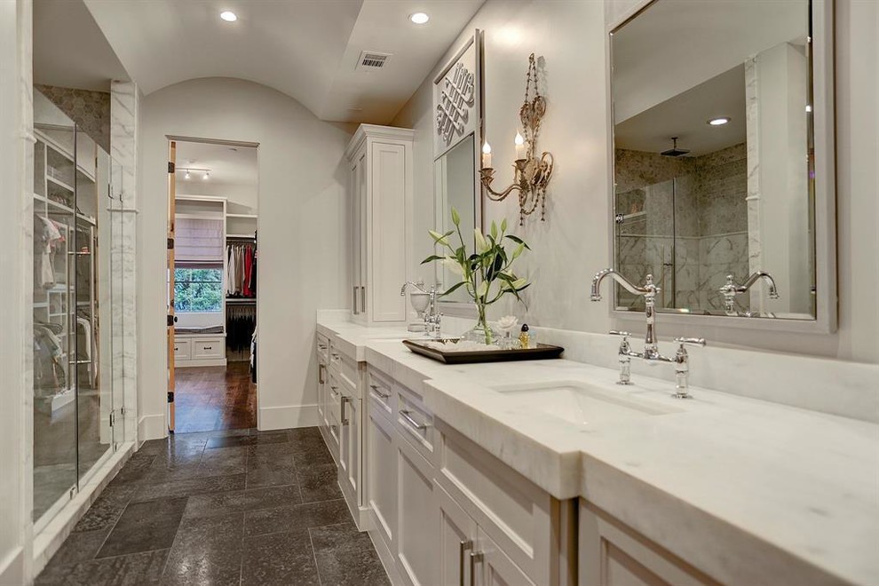 Example of a large classic master white tile and marble tile travertine floor and black floor bathroom design in Houston with shaker cabinets, white cabinets, a two-piece toilet, white walls, an undermount sink, quartzite countertops, a hinged shower door and white countertops