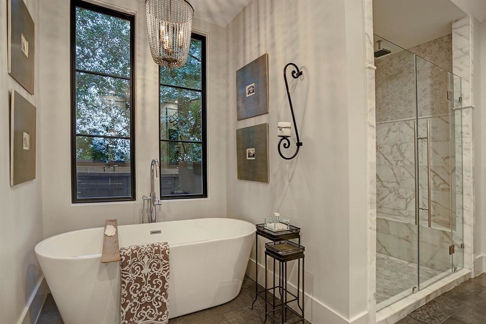 На фото: большая главная ванная комната в классическом стиле с фасадами в стиле шейкер, белыми фасадами, отдельно стоящей ванной, душем в нише, раздельным унитазом, белой плиткой, мраморной плиткой, белыми стенами, полом из травертина, врезной раковиной, столешницей из кварцита, черным полом, душем с распашными дверями и белой столешницей