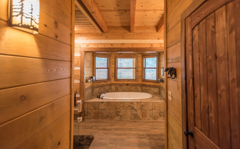 Bild på ett stort rustikt en-suite badrum, med möbel-liknande, skåp i slitet trä, ett platsbyggt badkar, en hörndusch, en toalettstol med separat cisternkåpa, skifferkakel, bruna väggar, mellanmörkt trägolv, ett nedsänkt handfat, träbänkskiva, brunt golv och dusch med gångjärnsdörr