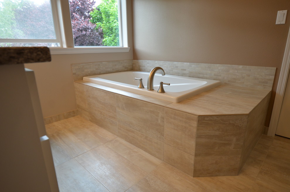 Medium sized traditional ensuite bathroom in Portland with a submerged sink, flat-panel cabinets, white cabinets, solid surface worktops, a built-in bath, an alcove shower, beige tiles, porcelain tiles, beige walls and porcelain flooring.