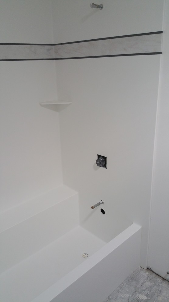 Réalisation d'une salle de bain minimaliste avec un combiné douche/baignoire.