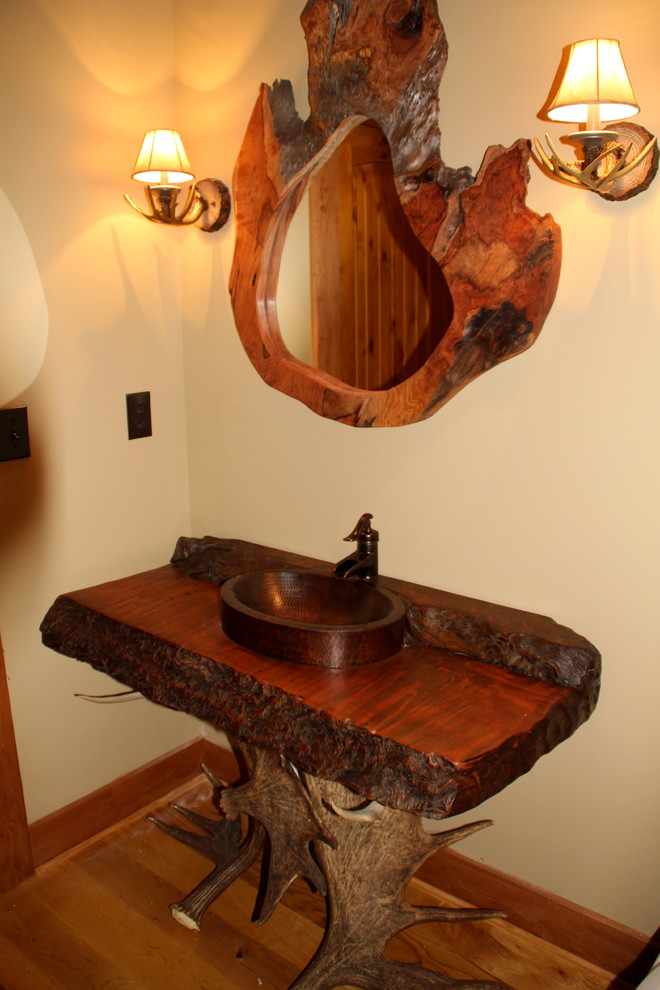 Example of a large mountain style master medium tone wood floor bathroom design in Nashville with a vessel sink, wood countertops and beige walls