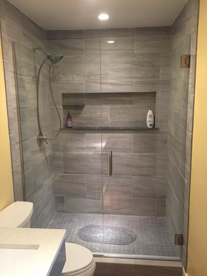 Modern inredning av ett mellanstort en-suite badrum, med grå skåp, en dusch i en alkov, en toalettstol med separat cisternkåpa, cementkakel, gula väggar, mellanmörkt trägolv, ett undermonterad handfat och bänkskiva i akrylsten