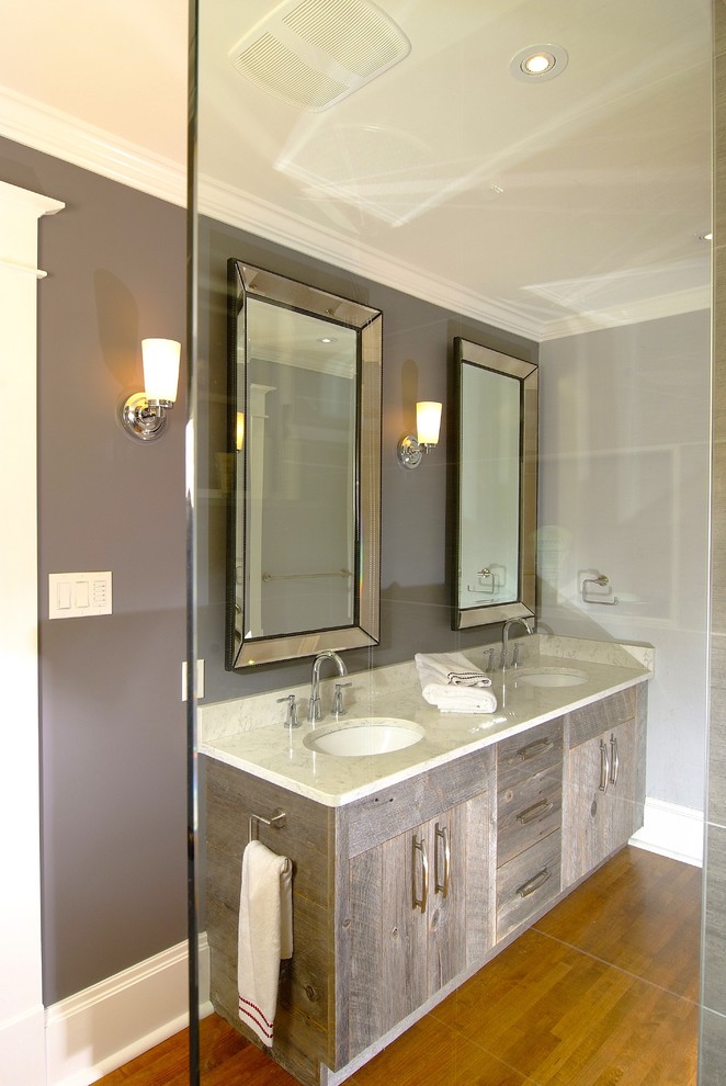 Modelo de cuarto de baño principal tradicional de tamaño medio con armarios con paneles lisos, puertas de armario de madera clara, paredes grises, suelo de madera oscura, lavabo bajoencimera y encimera de cuarzo compacto