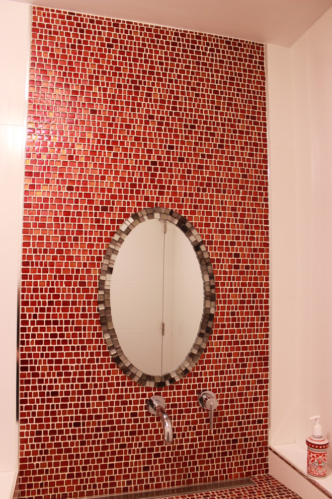 Foto på ett mellanstort funkis badrum, med röd kakel, glasskiva, röda väggar, klinkergolv i porslin, kaklad bänkskiva och grått golv